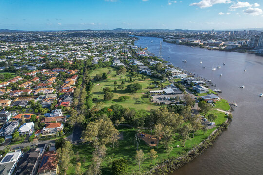 Aerial view of Brisbane River with Bulimba Golf Club and Vic Lucas Park surrounded by greenery and residential areas, Bulimba, Australia.
