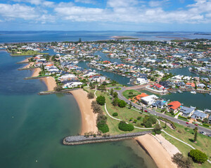 Aerial view of raby bay foreshore playground with beautiful coastline and residential homes, Moreton Bay, Australia.