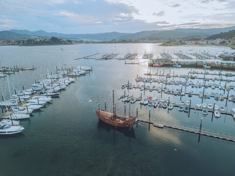 Aerial view of serene Carabela A Pinta port with boats and tranquil water, Baiona, Spain.