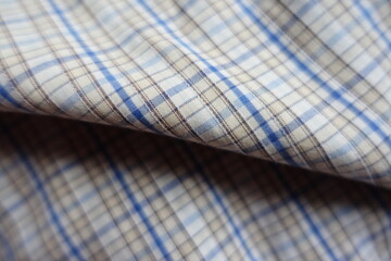 Folded white, blue and brown checkered cotton fabric