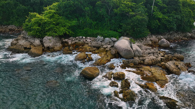 Aerial view of beautiful coastal scenery with rocky shore and lush forest, Ubatuba, Brazil.