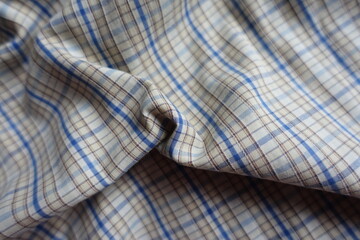Rumpled white, blue and brown checkered cotton fabric