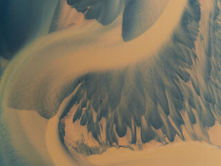 Aerial view of abstract patterns of a glacier river with serene curves and earth tones, Hvolsvollur, Iceland.
