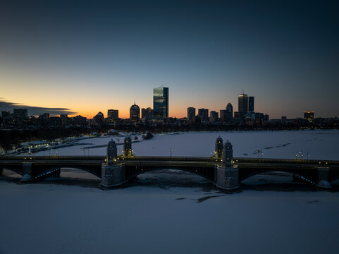 Aerial view of snowy skyline featuring Longfellow Bridge over the frozen Charles River with John Hancock Building and Prudential Center, Boston, United States.
