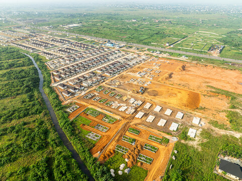 Aerial view of urban development and construction in a residential area with greenery and fields, Greater Taf City, Nigeria.