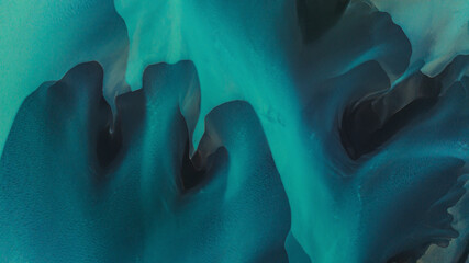 Aerial view of vibrant turquoise river with smooth organic shapes and serene patterns, Selfoss, Iceland.