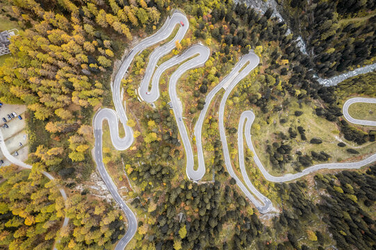 Aerial view of winding road through beautiful autumn forest at Maloja Pass, Maloja, Switzerland.