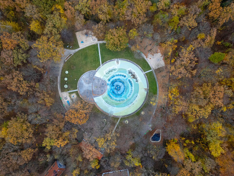 Aerial view of autumn park with colorful fall foliage and serene fountain, Planterwald, Berlin, Germany.