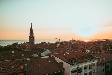 Naklejka premium Coastal town sunset with historic clock tower.