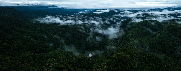 Fototapeta premium aerial view landscape rain forest and mist cover mountain valley, drone photography panorama.