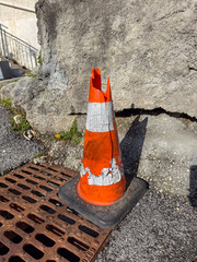 Damaged Traffic Cone on Rusty Drain Cover