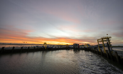 Fototapeta premium Landscape near Dagebüll harbor. Nature with sunrise on the North Sea coast. Rising sun on the sea. 