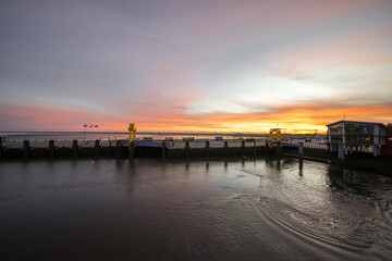 Obraz premium Landscape near Dagebüll harbor. Nature with sunrise on the North Sea coast. Rising sun on the sea. 
