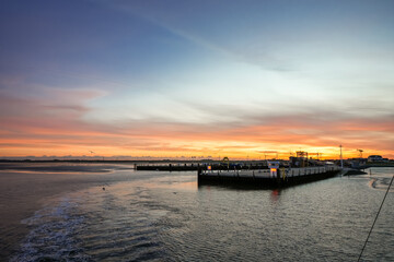 Naklejka premium Landscape near Dagebüll harbor. Nature with sunrise on the North Sea coast. Rising sun on the sea. 