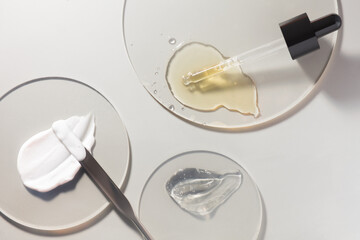 Cosmetic cream and gel and serum set smudge drops swatches with dropper and steel applicator stick...