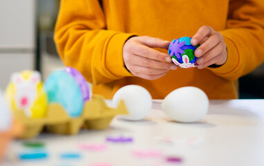 Child decorating easter eggs at home for spring celebration