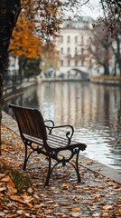 Fototapeta premium Weathered Wooden Bench Surrounded by Autumn Leaves by Calm Canal