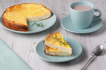 Delicious homemade cottage cheese casserole served with a warm cup of hot beverage on a wooden table
