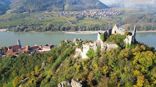 Aerial view of picturesque medieval town with fortress and vineyards along the Danube River in autumn, Durnstein, Austria.