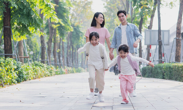 Parents walk their two daughters to school
