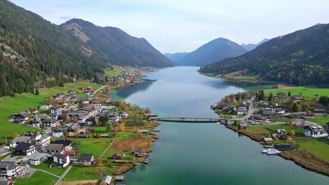 Aerial view of idyllic landscape with serene lake and picturesque village surrounded by mountains, Weissensee, Austria.