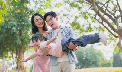 Young Asian family having a picnic in the park on the weekend
