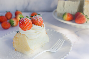 angel food cake light and fluffy sponge cake served with whipped cream and strawberry on white plate.
