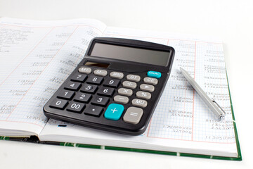 Calculator on top of financial report and stationery on desk. Accounting and auditing business concept.