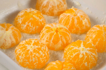 Pastry chef woman hands cooking pie placing peeled mandarin orange halves in baking dish. Professional baker preparing ingredients for homemade cake. Culinary, cuisine, domestic food recipe dessert.
