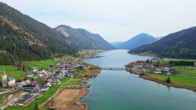 Aerial view of idyllic autumn landscape with Weissensee lake and village surrounded by mountains, Carinthia, Austria.