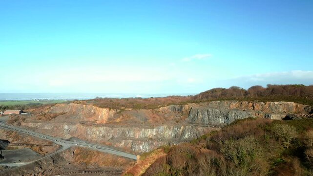 Forward moving aerial shot of a rock quarry on a sunny day. Filmed in 4K, 60 frames per second and in Rec709 color.