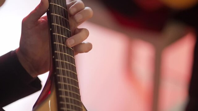 Close up of a musician playing a Portuguese guitar during a fado performance