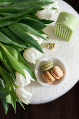 Cup with cappuccino and macarons, spring flowers tulips, morning concept, soy candle, woman's day, bedroom design