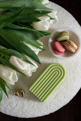 Cup with cappuccino and macarons, spring flowers tulips, morning concept, soy candle, woman's day, bedroom design