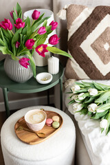 Cup with cappuccino and macarons, spring flowers tulips, morning concept, soy candle, woman's day, bedroom design