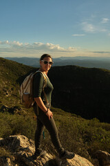 Naklejka premium Woman with a backpack on her back on top of a mountain