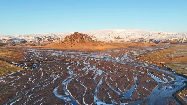 Aerial view of river veins flowing through a winter mountain landscape with a glacier, Vik i Myrdal, Iceland.