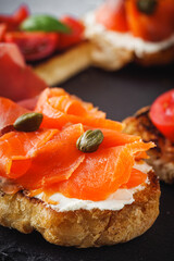 delicious Italian bruschetta with tomatoes salmon and prosciutto