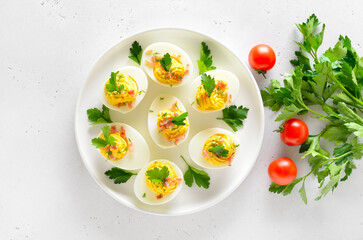 Stuffed eggs with egg yolk, bacon, mustard and parsley