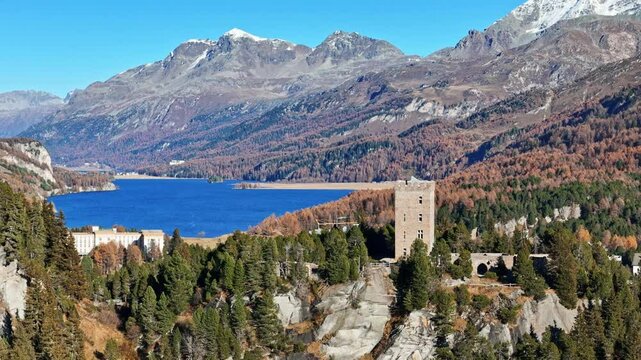 Aerial view of silsersee lake surrounded by majestic mountains and serene forests in autumn, Maloja, Switzerland.