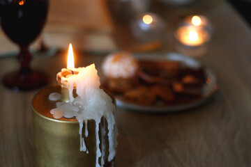 Books, lit candles, red wine, snacks and various deocration on the table. Dark academia or Halloween concept. Selective focus.