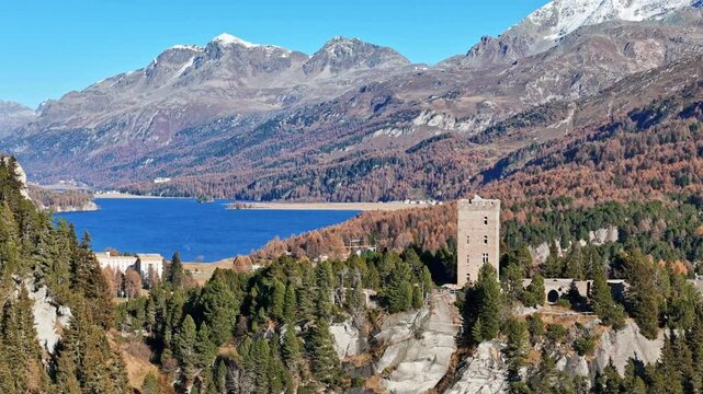 Aerial view of silsersee lake surrounded by majestic mountains and vibrant autumn foliage, Maloja, Switzerland.