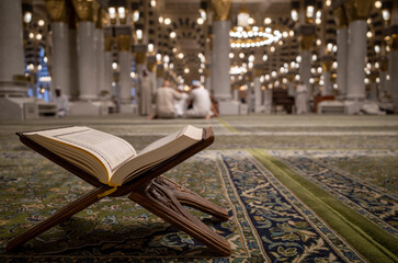 The holy book of the Quran is opened on a green carpet at the Prophet Mosque, Masjid Nabawi in the...