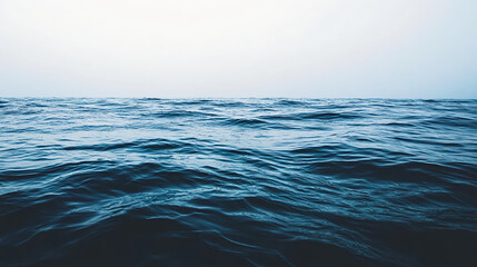 Obraz premium Realistic photograph of an endless ocean, deep black water, calm and dark with subtle ripples on the surface, illuminated by soft light from above, creating a mysterious atmosphere. The background 