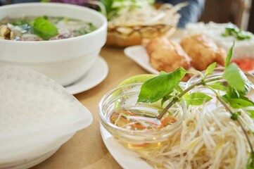 A plate of sugarcane prawns, fresh bean sprouts, nuoc cham sauce and basket of fresh herbs for rice paper rolls at Phu Quoc, a Vietnamese Chinese restaurant in Cabramatta - Sydney, NSW, Australia 