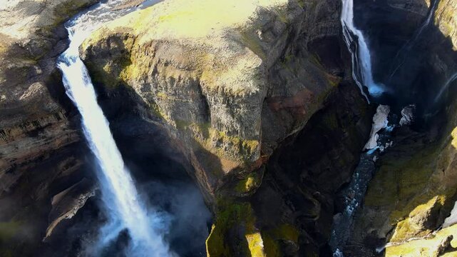 Aerial view of breathtaking Haifoss and Granni waterfalls cascading through a majestic canyon in the Icelandic Highlands, Iceland.