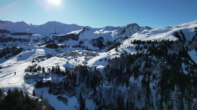 Skiers enjoy the pristine slopes of Stoos, Switzerland. The clear blue sky, fresh snow, and beautiful mountain scenery make it a perfect winter sports destination
