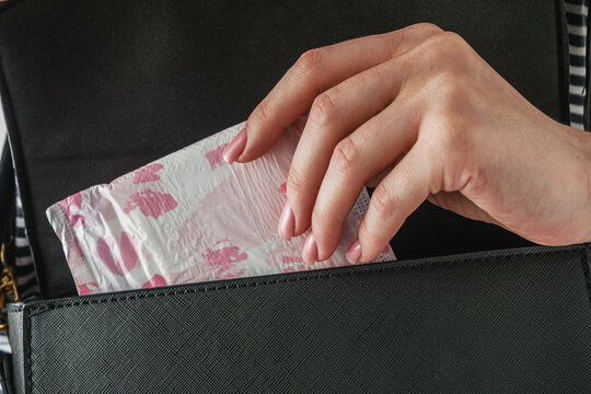 young girl takes out a sanitary napkin from her handbag, hygiene concept