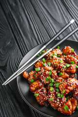 delicious juicy Japanese teriyaki chicken on a black wooden rustic background