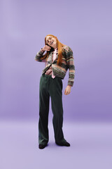 Fototapeta premium Young queer man with red hair showcasing stylish attire against a modern backdrop